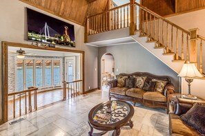 Relax in this serene space with a view of the water, featuring a comfortable sofa, coffee table, and decorative accents.