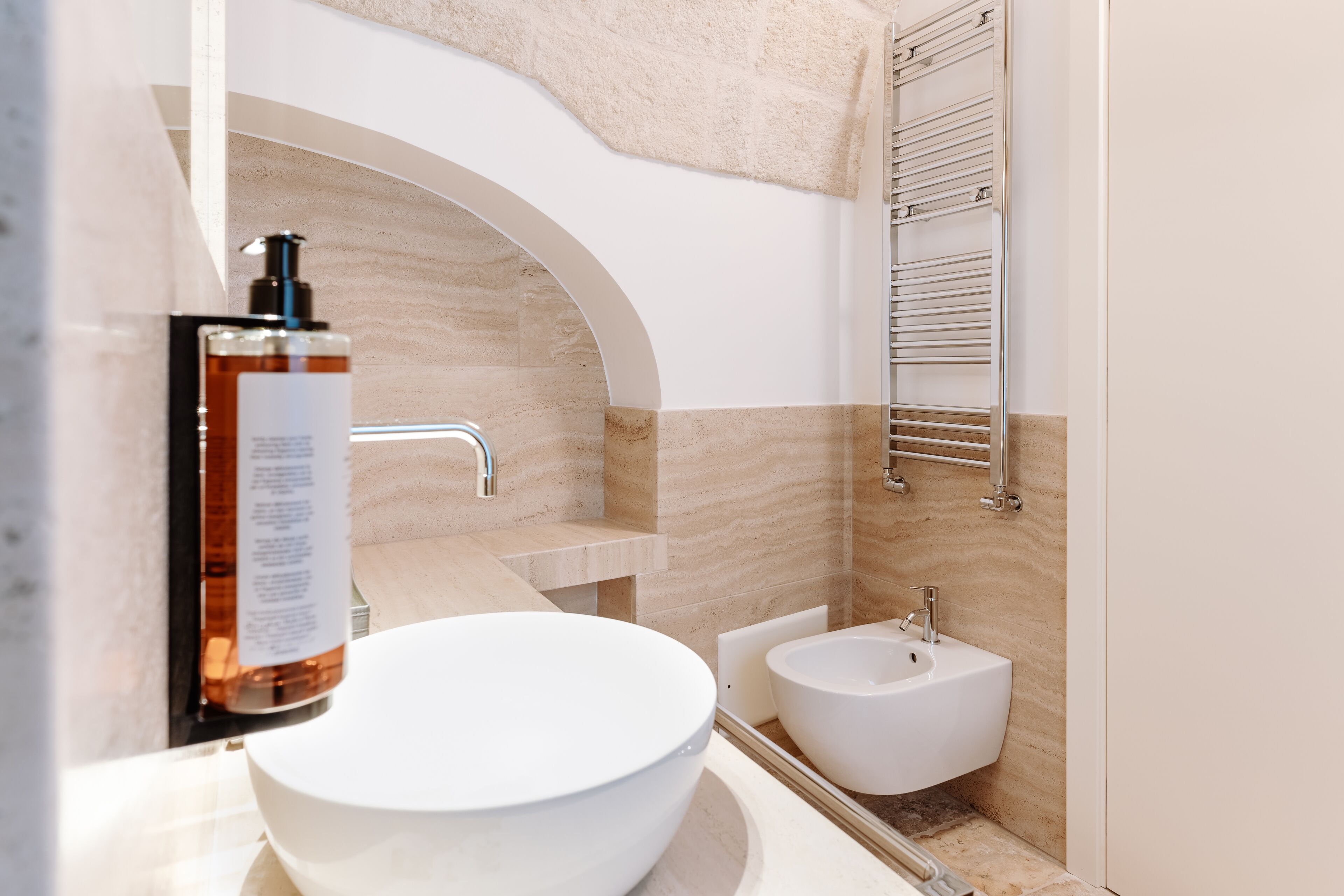 Une salle de bain moderne avec un grand lavabo blanc, un bidet et un porte-serviettes.
