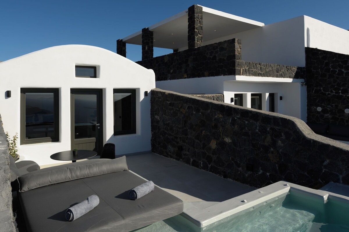 A modern house with a swimming pool, stone walls, and a patio area.