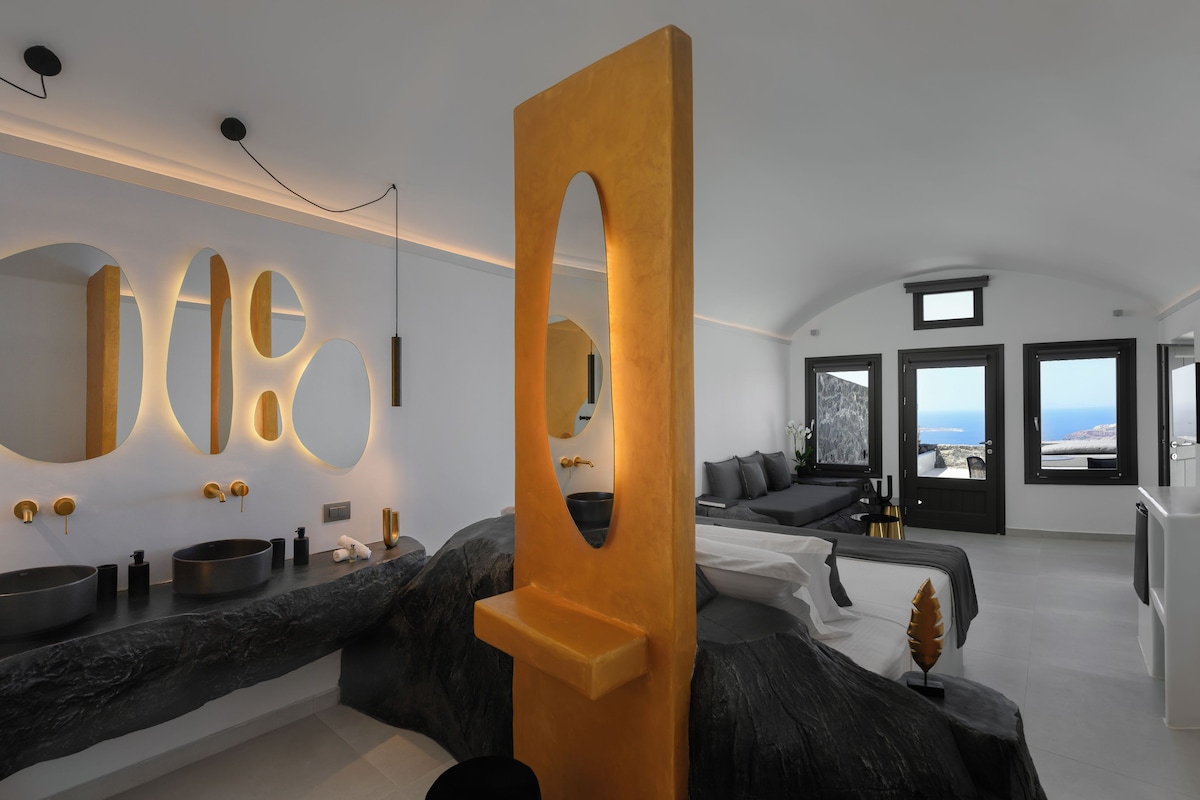 A modern bathroom with a large mirror, a round sink, and a unique wooden accent piece.