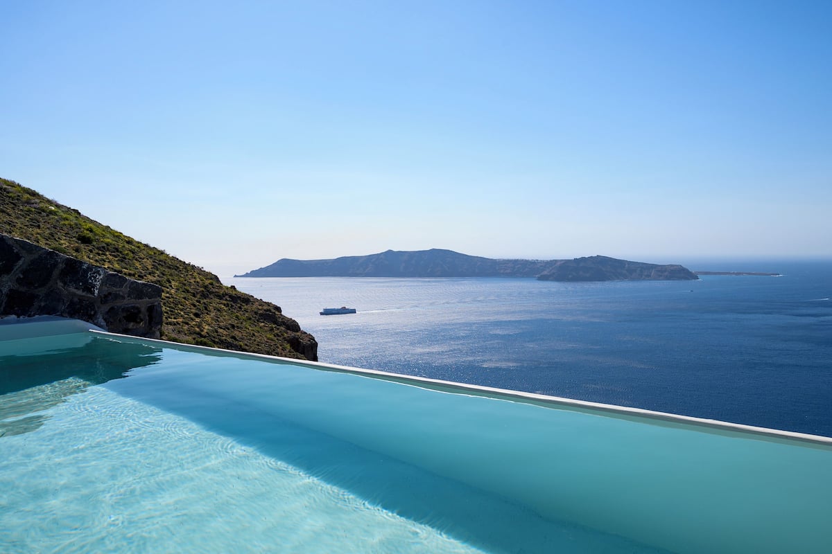 A clear view of a swimming pool with a view of the sea and distant islands.