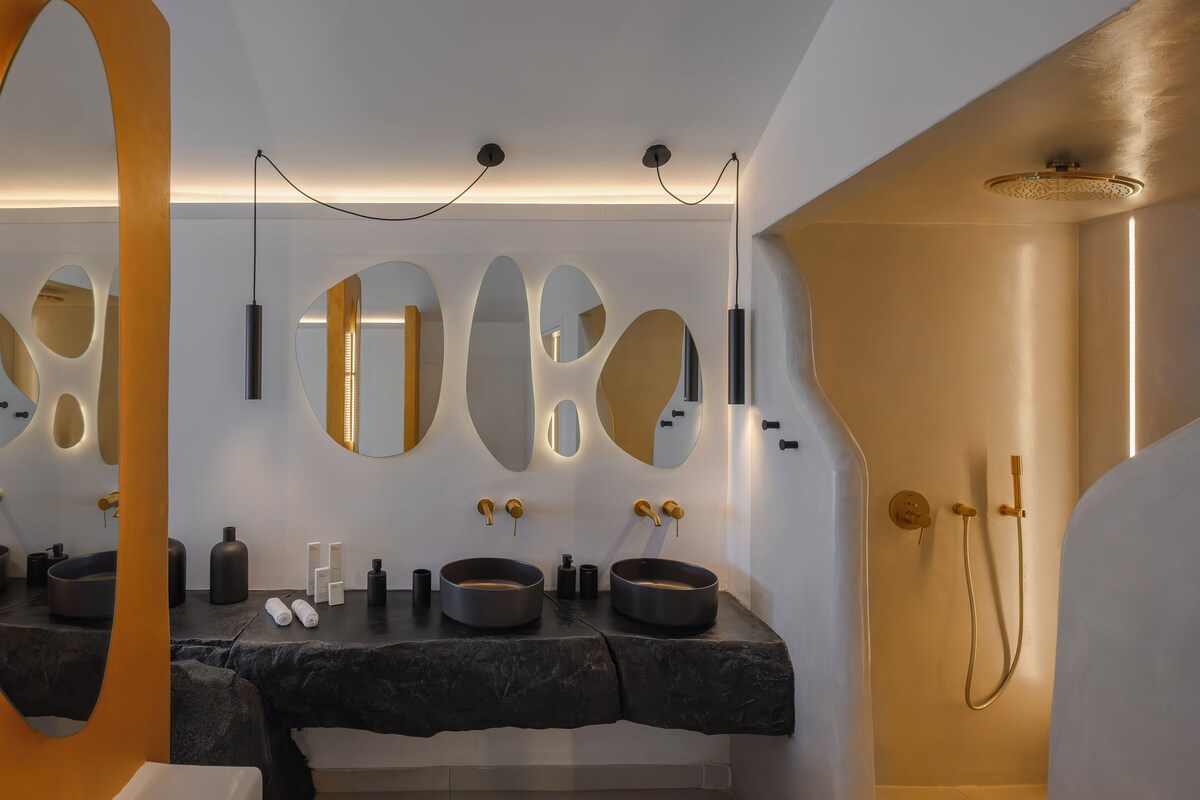 A modern bathroom with two sinks, a large mirror, and a shower area.