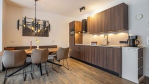 Eine moderne Küche mit Holzausstattung, einem Backofen und einer Kaffeemaschine.