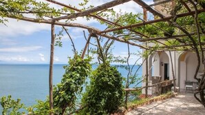 Un camino de piedra que conduce a un edificio con vista al mar.