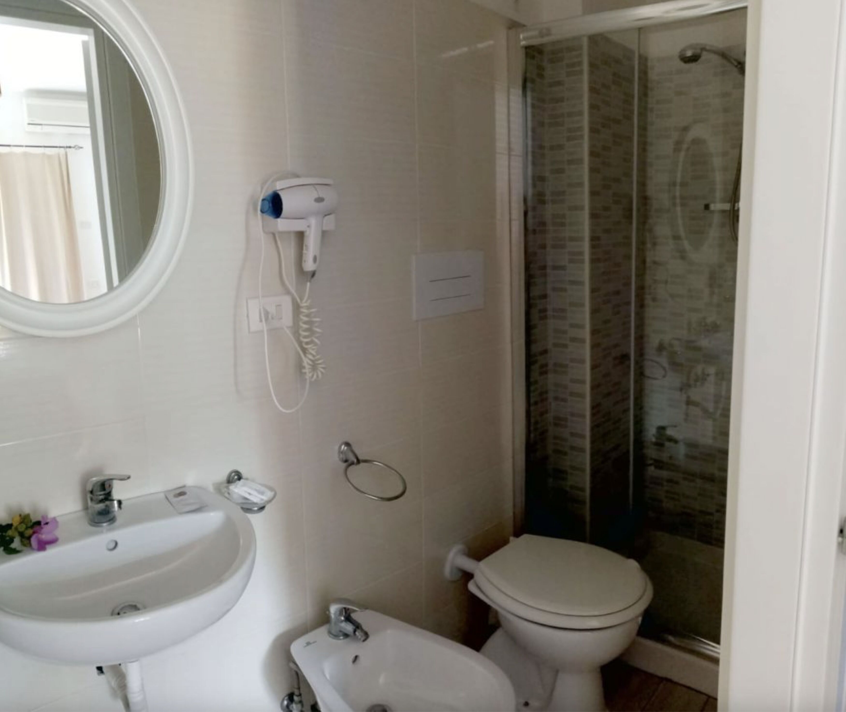 A bathroom with a sink, toilet, and a glass-enclosed shower.