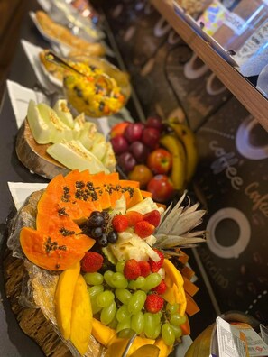 A buffet with various fruits and vegetables arranged on a table. - Pousada Canto do Gravatá (Penha)