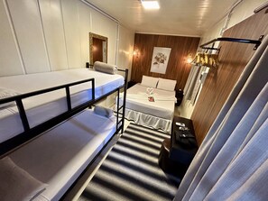 A compact hotel room with bunk beds, a small bedside table, a wall-mounted light fixture, and a framed picture on the wall. - Pousada Canto do Gravatá (Penha)
