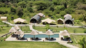 Ein Resort mit Strohdachschirmen, einem Swimmingpool und kuppelförmigen Unterkünften.