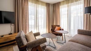 Ein modernes Wohnzimmer mit einem Flachbildfernseher, einem Holztisch und zwei Sofas.