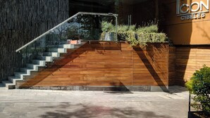Un edificio moderno con una escalera de madera que conduce a una entrada de cristal.