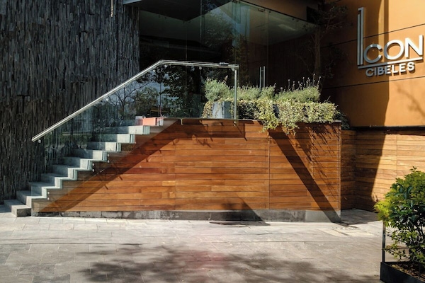 Sleek building entrance framed by greenery, walkable to Roma Norte's cafes and Reforma