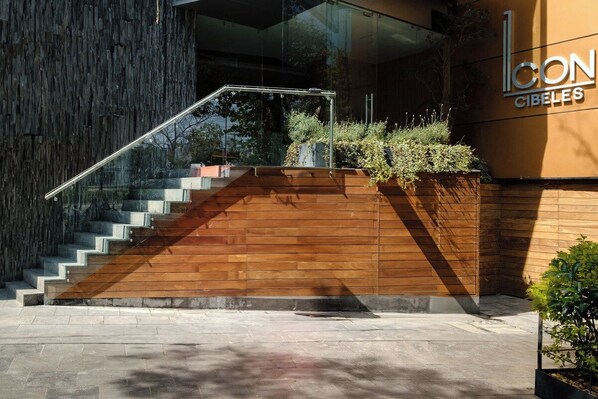 A modern building with a wooden staircase leading to a glass entrance.