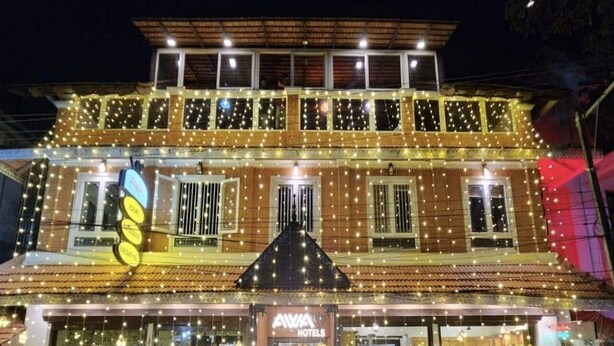 A two-story building with a sign for "AXIA HOTELS" at the entrance. - AVVA Hotels (Kochi)
