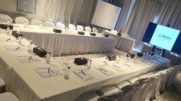 A conference room with a long table set for a meeting, equipped with nameplates, water bottles, and notepads.