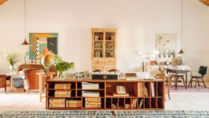 A spacious room with high wooden beams, a wooden cabinet, a globe, and a desk with books. - Casas da Quinta de Cima (Vila Real Santo Antonio)