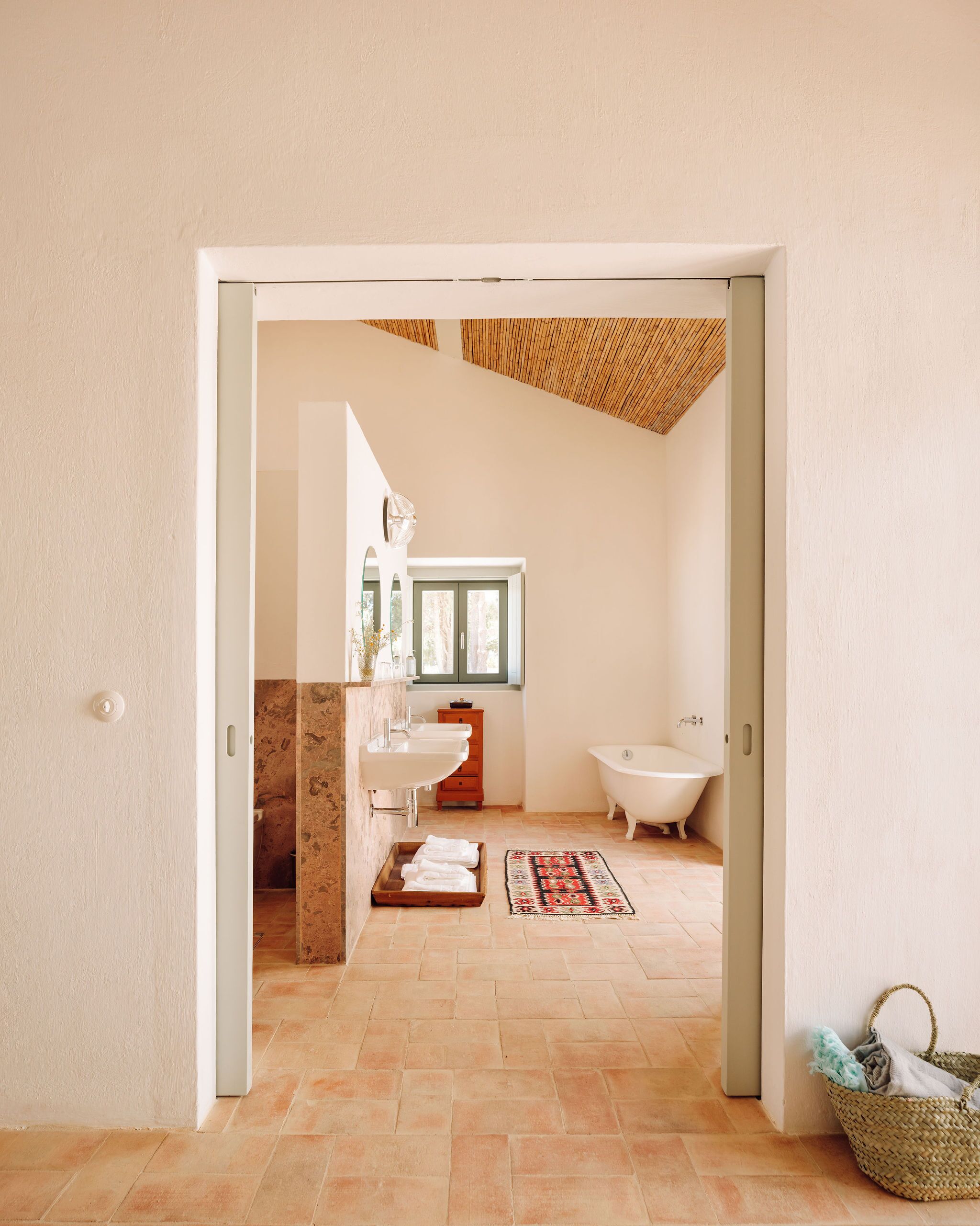 Une salle de bain moderne avec une baignoire sur pieds, un meuble-lavabo en bois et un sol carrelé.