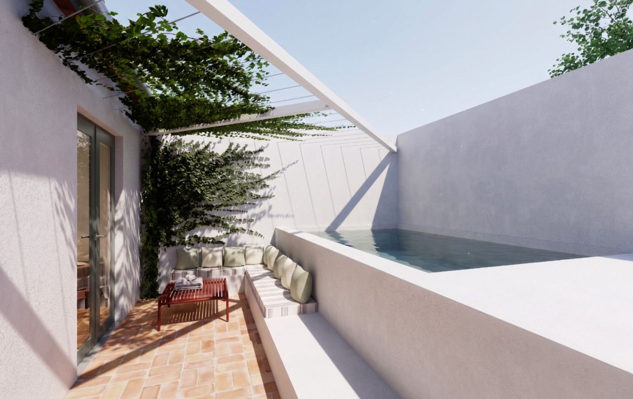 A modern outdoor patio with a built-in hot tub, a seating area with cushions, and a glass door leading to an interior space.
