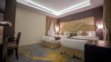 A hotel room with two beds, a desk, and a chair.