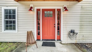 A house with a red door, a wooden bench, and a hose on the side. - Secluded Catskill Home w/ Hiking Trails On-site! (Catskill)