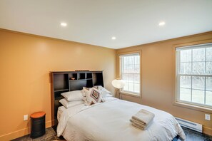 A bedroom with a bed, a nightstand, a lamp, and a window. - Secluded Catskill Home w/ Hiking Trails On-site! (Catskill)