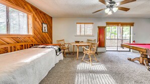 A room with a bed, a dining table with chairs, a pool table, and a ceiling fan. - Expansive Ruidoso Home: Private Hot Tub + Deck (Ruidoso)