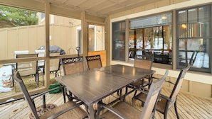 An outdoor patio with a dining table and chairs, a grill, and a covered area with windows. - 'cozy Cove' Near Waterparks, Zip Line, Ski & More (Tannersville)