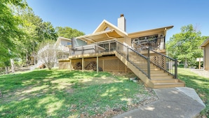Ein zweistöckiges Haus mit einer Veranda, einer Treppe und einem umzäunten Garten.