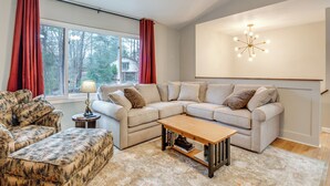 A living room with a sectional sofa, a patterned armchair, a wooden coffee table, and a lamp. - Pet-friendly Fletcher Home - 13 Mi to Asheville! (Fletcher)