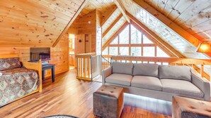 A cozy cabin interior with a wooden ceiling, a sofa, a patterned armchair, and a television. - Peaceful Cabin w/ Hot Tub: 11 Mi to Blue Ridge! (Epworth)