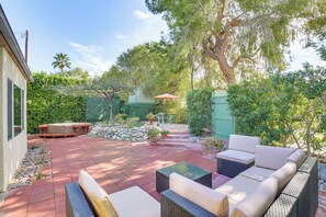 A patio with wicker furniture, a hot tub, and a covered seating area. - Palm Springs Studio w/ Outdoor Oasis & Hot Tub! (Palm Springs)
