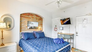 Une chambre à coucher avec un lit, une télévision, un bureau et un miroir.