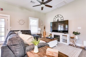 A living room with a sofa, coffee table, TV, fireplace, and decorative items.