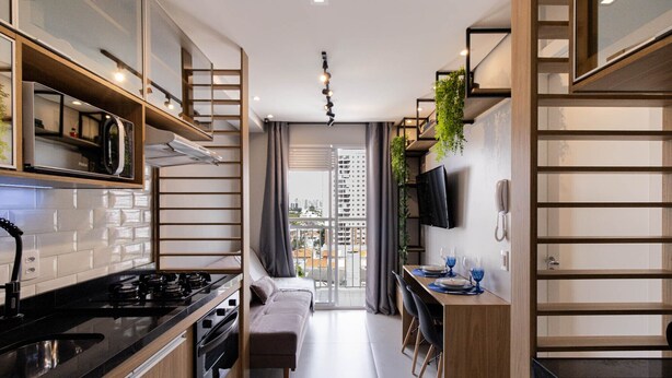 Une cuisine moderne équipée d’une cuisinière, d’un four et d’un coin repas avec un banc et des chaises.