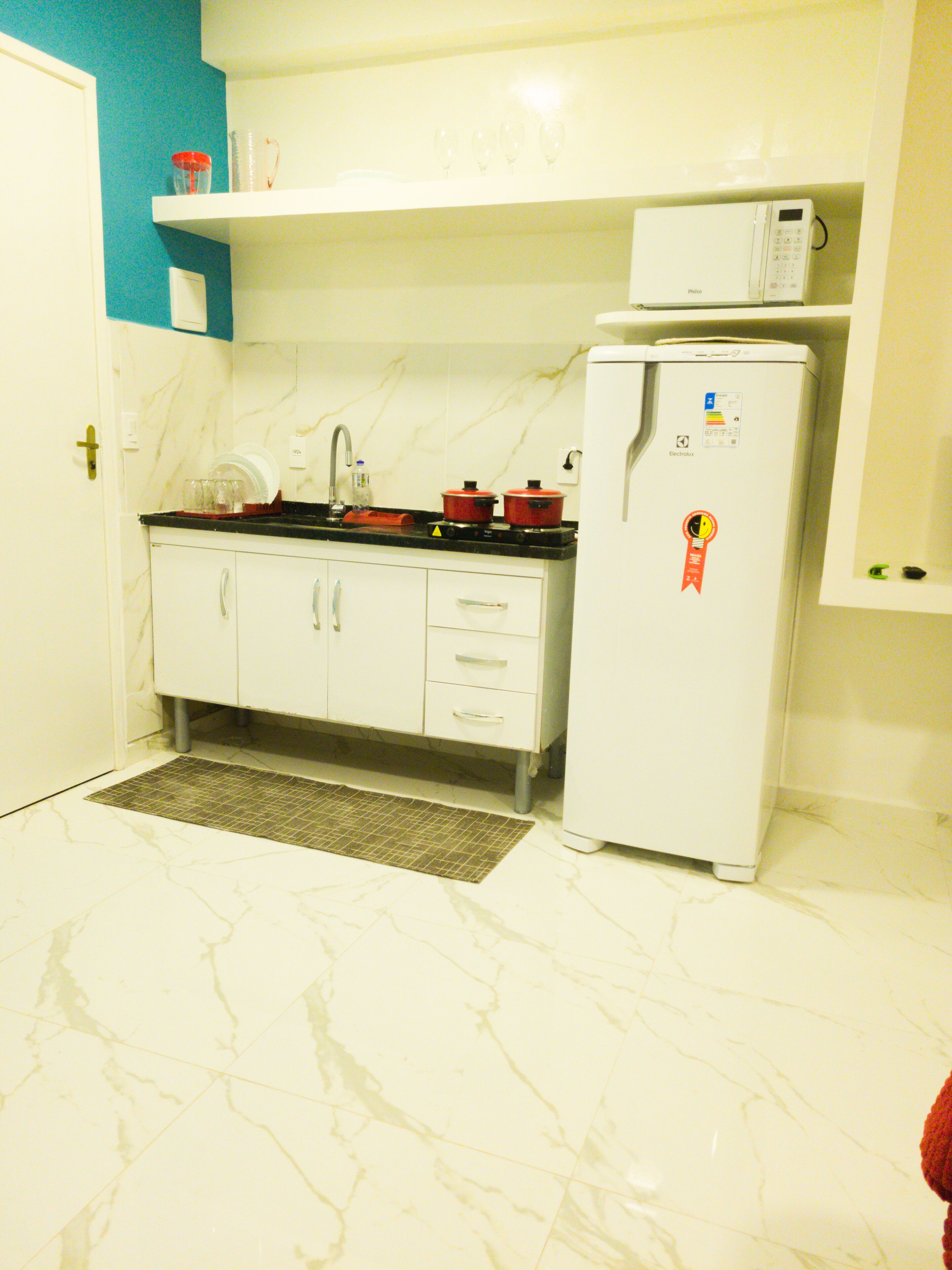 Kjøleskap, mikrobølgeovn, kokeplater og høy barnestol