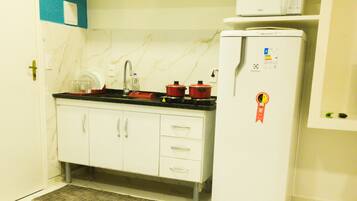 Kjøleskap, mikrobølgeovn, kokeplater og høy barnestol