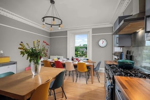 Une cuisine moderne avec un coin repas, une grande fenêtre et une vue sur l’extérieur.