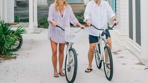Two people on bicycles in a covered outdoor area with a white building in the background. - Seaside, FL Beach Home - Close to Pool & Beach; + 2 Adult Bikes! (Santa Rosa Beach)