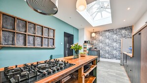 A modern kitchen with a skylight, a large window, and a built-in stove.