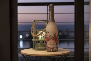 A bottle of Anabelle Cuvee Rose Champagne on a round table with a metal wire basket and a glass lantern in the background.