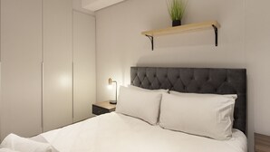 Une chambre à coucher comprenant un lit, une table de chevet, une lampe de chevet, une armoire et une étagère avec une plante.