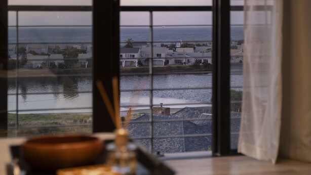 Une vue à travers une fenêtre, avec une table au premier plan.