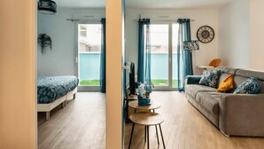 Un apartamento moderno con sala de estar, un dormitorio y un balcón.