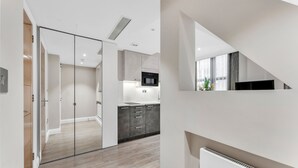 A modern kitchen with a microwave, stove, and cabinets. - Cleveland Residences Farringdon (London)