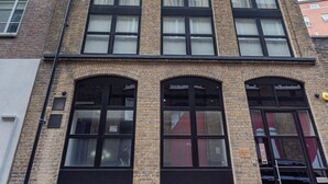 A multi-story building with large windows and a brick facade. - Cleveland Residences Farringdon (London)