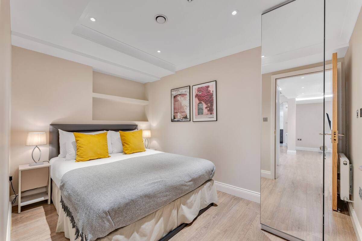 A bedroom with a bed, bedside table, and a wardrobe.