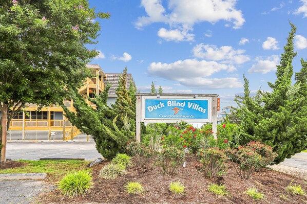 A sign for Duck Blind Villas with a view of a building in the background. - Heaven's Nest -- First Floor Duck Condo with direct access to Beach and Pool (Kitty Hawk)
