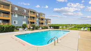 A swimming pool with a no diving sign, surrounded by lounge chairs and a multi-story building with balconies. - Heaven's Nest -- First Floor Duck Condo with direct access to Beach and Pool (Kitty Hawk)