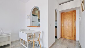Uma casa de banho moderna com uma toucador branco, um espelho e uma cadeira de madeira.