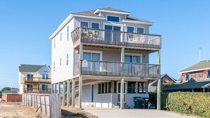 A multi-story residential building with balconies, a covered porch, and a visible garage door.