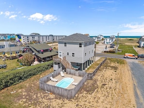 A multi-story building with a swimming pool, located near a beach. - Tapped Out - KDH MP 8, Ocean View, 180 Yds to Beach, Pool, Hot Tub, Pets OK, Flex Stays (Kill Devil Hills)